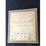 A nineteenth century framed sampler with panel of alphabet & numbers, birds, windmills, vases,