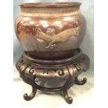 A nineteenth century Japanese bronze jardinière on stand, the bowl embossed with dragons beneath a