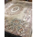 A large thick-pile mushroom coloured bedroom carpet woven with central oval pastel coloured floral