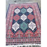 An Indian style rug woven with nine stepped medallions on blue flowerhead field, framed by