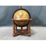 A globe with hinged cover revealing an ice bucket, the stand on four baluster turned legs above a