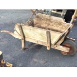 A large old wood wheelbarrow with ash frame and angled sides, fitted with pneumatic tyre - A/F. (