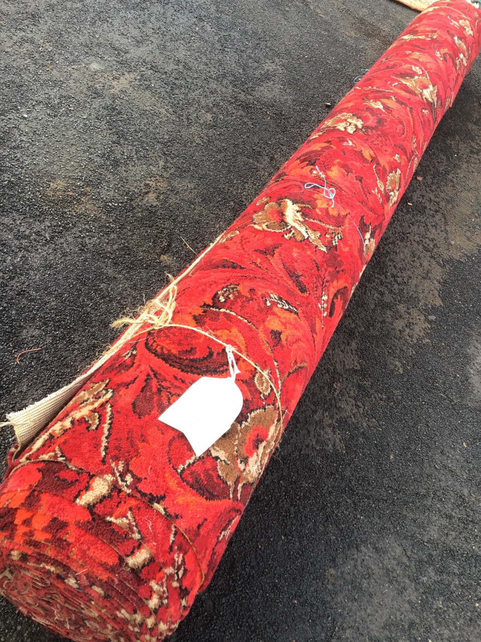 A roll of Axminster carpet of red floral scrolled design that has been in store for 20yrs, never