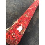 A roll of Axminster carpet of red floral scrolled design that has been in store for 20yrs, never