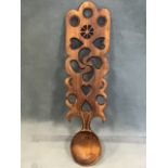 A carved love spoon, the rectangular wide handle with pierced decoration of hearts, crescents,