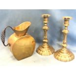 A pair of nineteenth century brass candlesticks with urn shaped candleholders above triangular