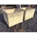 A pair of square composition stone garden tubs with leaf cast rims, the sides decorated with