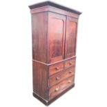 A Victorian mahogany press with angled cornice above rounded panelled doors enclosing linen shelves,