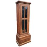 An Edwardian oak gun cupboard with glazed door enclosing a baize lined interior with two small