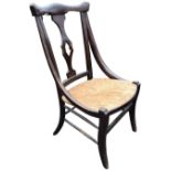 An unusual Edwardian stained nursing chair with pierced splat beneath shaped back rail having