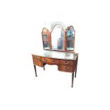 A bowfronted mahogany boxwood inlaid dressing table, the back with three arched mirrors on easel