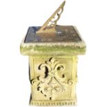 A square brass sundial set on composition stone plinth cast with foliate scrolled panels on ribbed