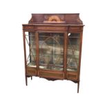 An Edwardian breakfront mahogany display cabinet, the back with floral marquetry panel above a