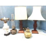 A pair of carved rosewood chinoiserie tablelamps with pierced character style fretwork supports on
