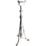 A Victorian wrought iron oil lamp stand, the telescopic column with brass mounts having scrolled