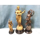 Three late nineteenth century spelter figurines, the bronzed ladies on circular ebonised plinths -