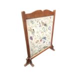 An oak framed Victorian firescreen with crewelwork panel of birds, flowers and entwined foliage on