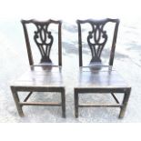 A pair of nineteenth century oak Chippendale style chairs with shaped back rails above pierced