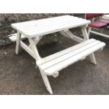 A 4ft painted garden table with chamfered battens to top raised on angled legs, the integral benches