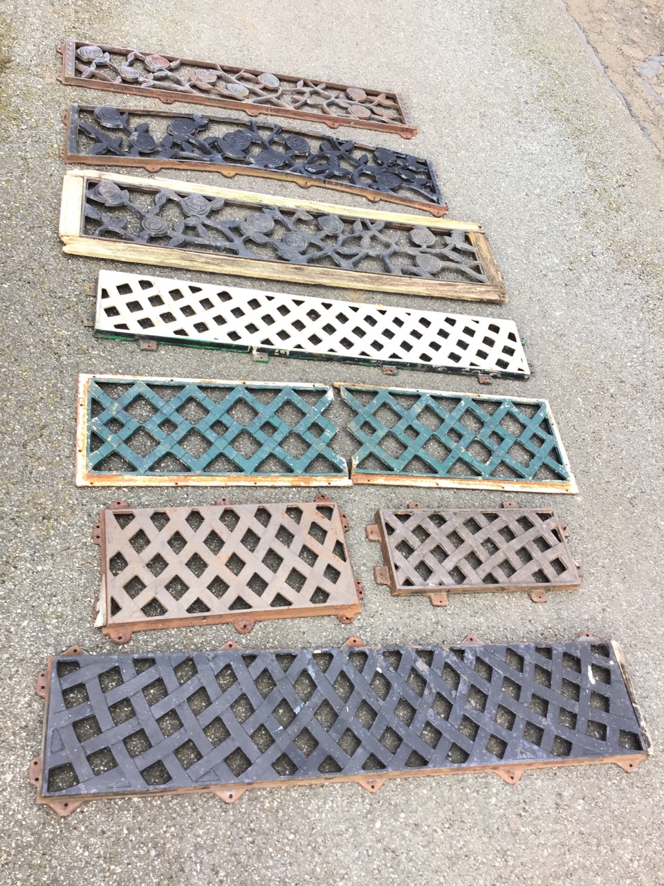 Eight metal grill type rectangular cast iron panels from garden seats, some with entwined foliage,