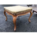 A nineteenth century square walnut stool, the seat re-upholstered with shaped aprons, raised on