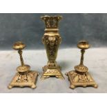 A pair of late C19th brass candlesticks with an associated square tapering vase, all decorated