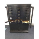 An Edwardian ebonised oak estate cabinet, the glazed top containing twenty-five drawers mounted with