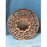 An arts & crafts copper plaque with pierced leaf embossed border and waved rippled rim, the