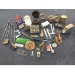 A box of metal items including oil lamps, cans, tools, an enamelled tin jug, cast iron, a