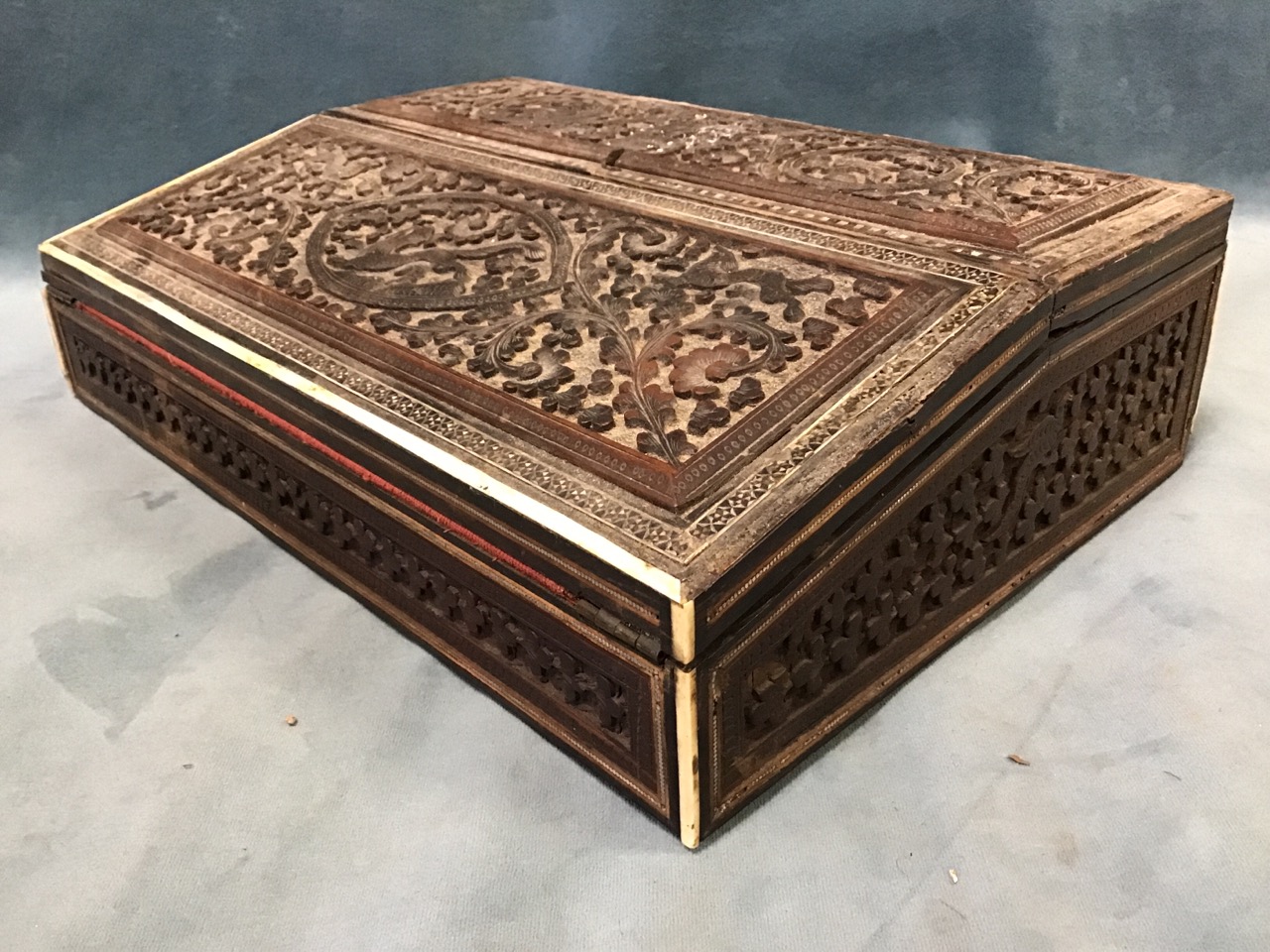 A late Victorian anglo-indian writing box, with two hinged covers carved with animal and birds