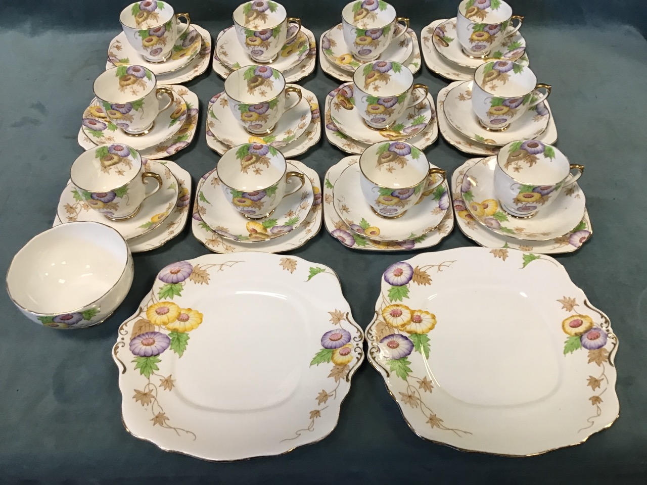 A Roslyn China twelve-piece teaset decorated in the Marigold pattern, enamelled with yellow & purple