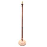 A mahogany standard lamp, the tapering turned column with brass collar, above a mound turned