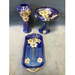 Three pieces of Maling decorated with gilded daffodils on blue lustre ground - a waisted vase, a