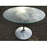 A circular table with plate glass top on chrome column support with spreading weighted base. (39.