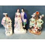 Three large Victorian Staffordshire flatback figures - a formal couple, two young men with dog
