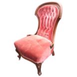 A Victorian spade-back mahogany chair, the back with cushion moulded frame and scroll carved arms