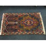 An oriental belouchi prayer rug woven with rectangular panel and twin subsidiary panels with