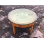 A circular 60s oak coffee table with thick plate glass top cut with sea motifs above a bijouterie