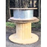 A large pine cable drum, suitable for a garden table - 49in x 32in; and another smaller with tin