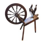 A nineteenth century stained spinning wheel with angled platform on three turned supports, the oak