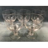 A set of five antique glass rummers with cup shaped bowls on squat knopped columns above thick