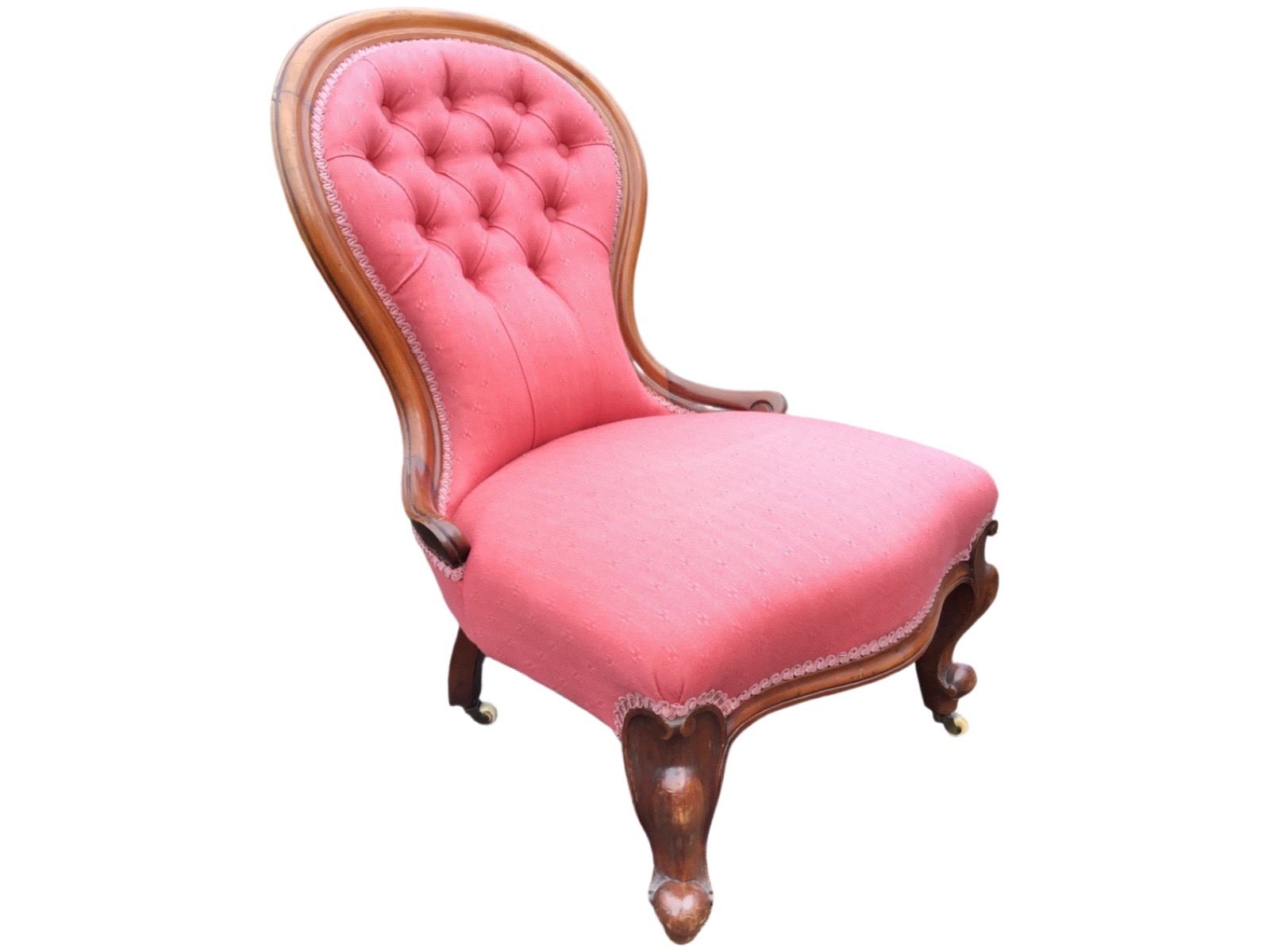 A Victorian mahogany spoonback chair with cushion moulded frame and scroll carved arms to button