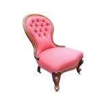 A Victorian mahogany spoonback chair with cushion moulded frame and scroll carved arms to button