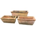 A set of three rectangular terracotta garden troughs with square moulded rims above rounded tapering