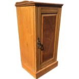 A Victorian ash bedside pot cupboard with shaped upstand to chamfered top, above a fielded