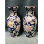 A pair of Chinese baluster vases with waisted necks, decorated with pastel flowers on blue