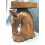 A carved hardwood stool in the form of a horses head, with rectangular platform and oval scalloped