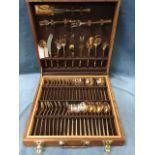 A walnut cased set of brass cutlery by Christiaans - eight settings with knives, forks, spoons,