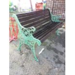 A rectangular cast iron garden bench with slatted back & seat on scrolled supports, the arms cast