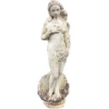 A composition stone garden statue of Venus with flowing hair hiding her modesty, standing on shell